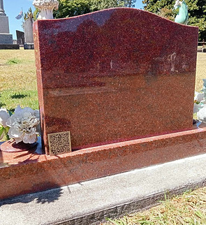 A QR code plaque mounted on a headstone